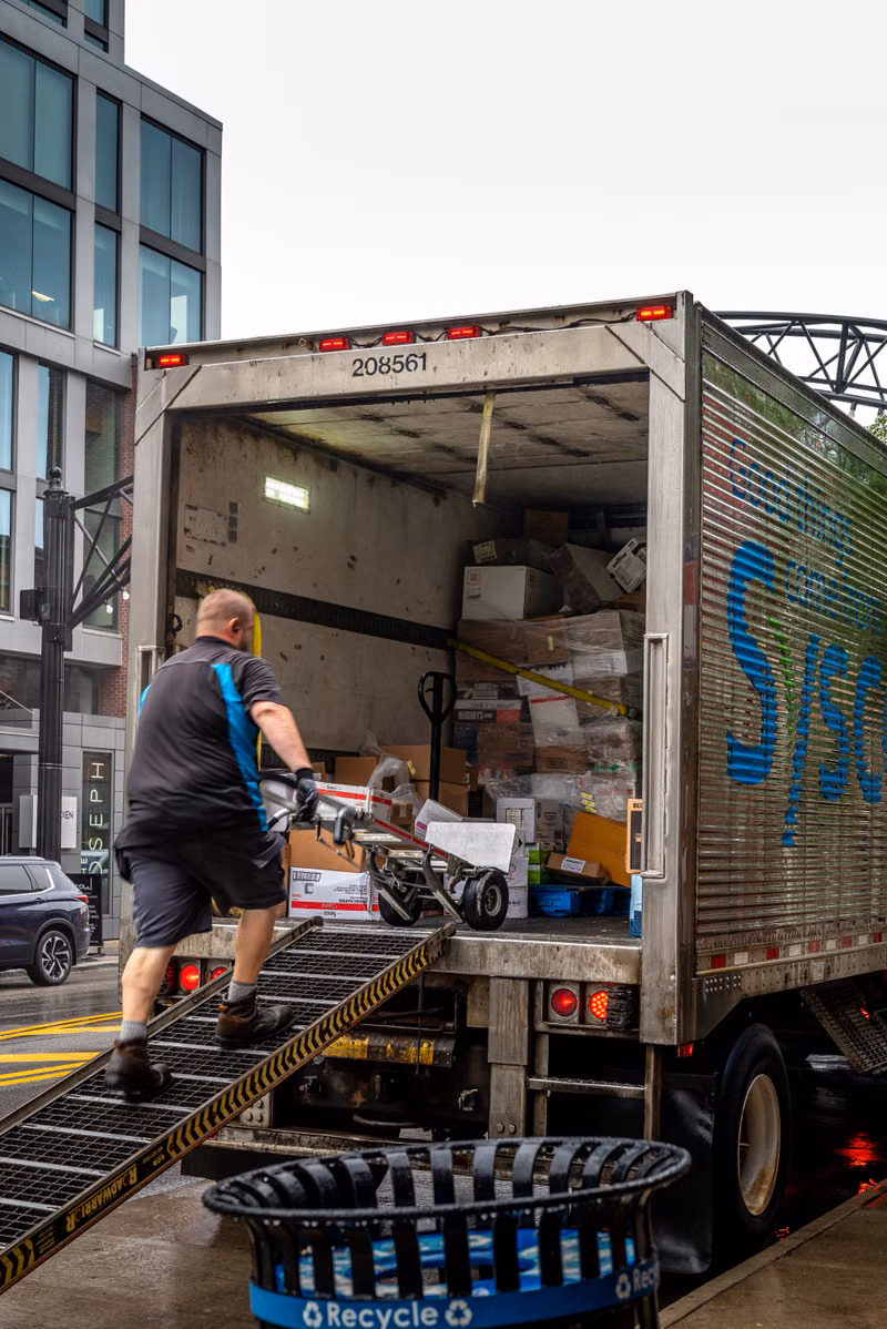 Commercial junk removal workers loading discarded business items at a Vista property